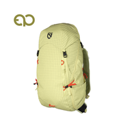 The NEMO Equipment Resolve™ Women’s 35L Endless Promise® Technical Active Daypack features a light green grid pattern, black buckles, orange drawstrings, side mesh pockets, and NEMO-exclusive fabrics. Shown on white with logo at top left.